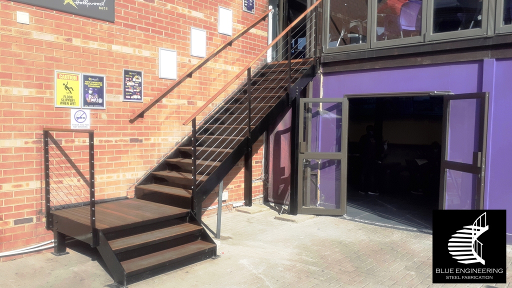 Steel staircase with flat plate stringers and steel treads clad with balau, installed with cable baustrades. Johannesburg, Pretoria, Durban, Gauteng, KwaZulu Natal